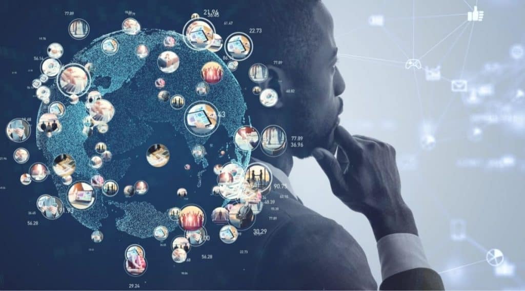 Ilustracja do artykułu: System rekrutacyjny, który myśli i czuje jak rekruter. Na pierwszym planie przedstawiona jest cyfrowa grafika kuli ziemskiej z naniesionymi na nią fragmentami zdjęć z różnym miejsc świata, na których znajdują się ludzie i laptopy. Na drugim planie profil znajduje się profil mężczyzny rasy czarnej, wpatrzonego przed siebie w graficzne przedstawienie sieci internetowej.