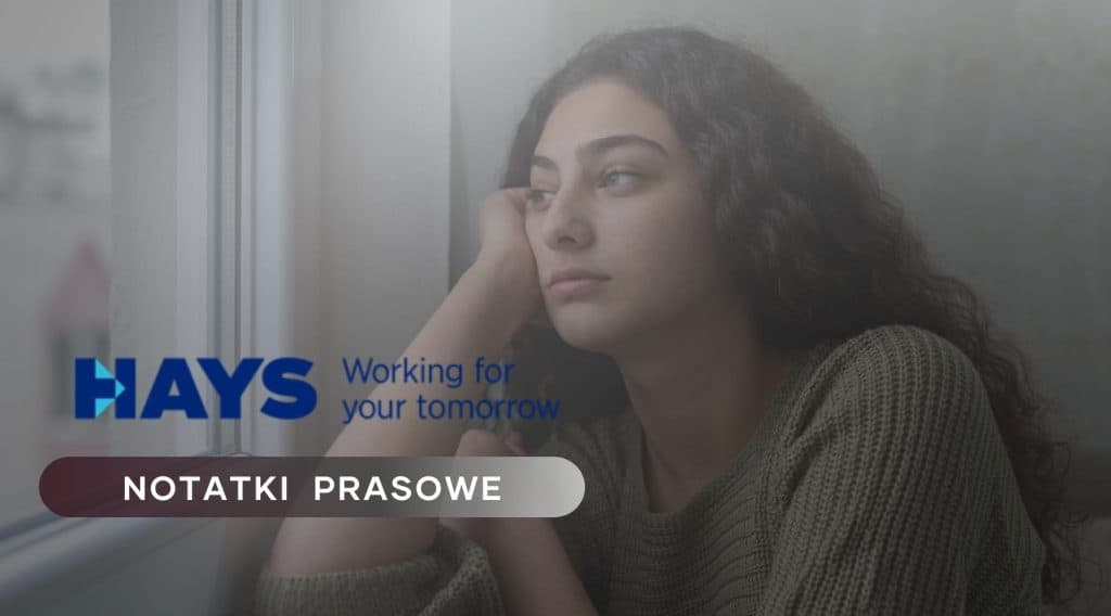 Zdjęcie jest ilustracją do artykułu Młodzi pracownicy, wyzwania edukacyjne i luka kompetencji. Przedstawia młodą kobietę wpatrzoną w widok za oknem. W lewym dolnym rogu znajduje się logo HAYS i tytuł działu: Notatki prasowe.