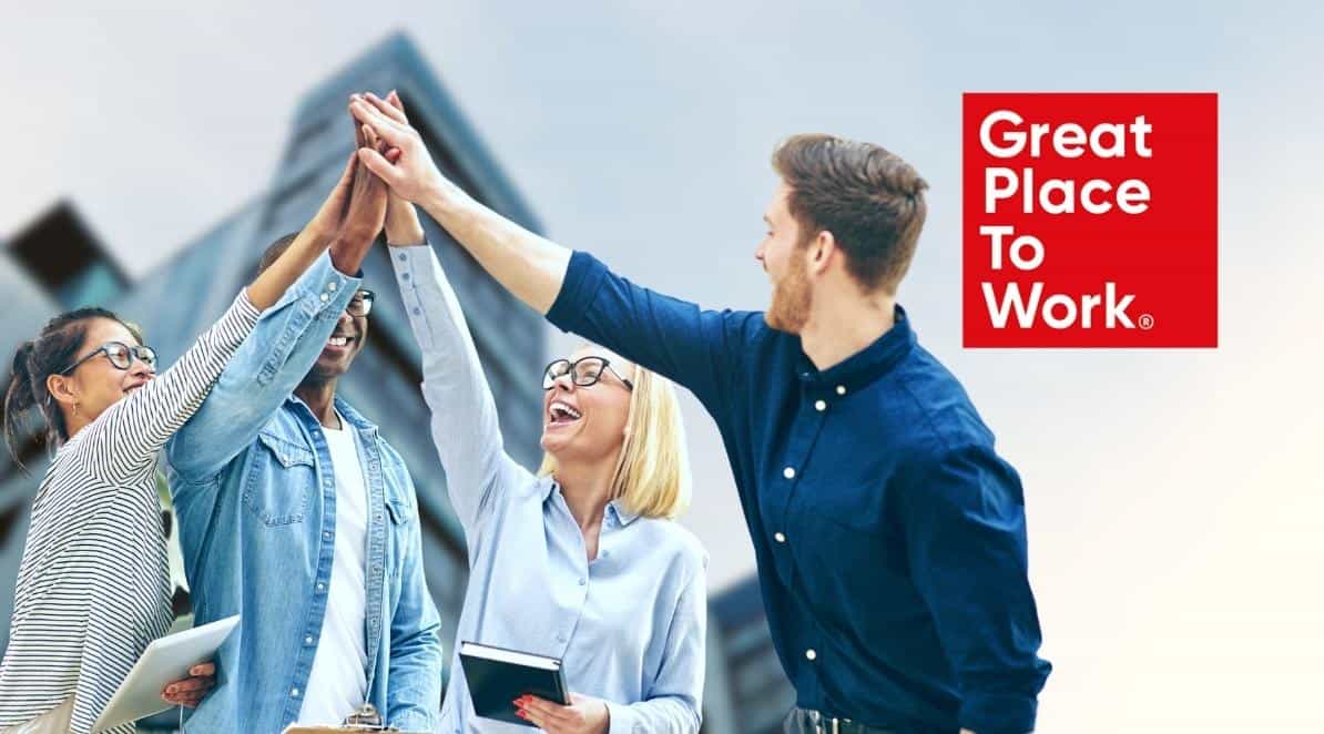 Zdajecie jest ilustracją do artykułu: Ranking najlepszych miejsc pracy w Polsce w 2022 roku. Przedstawia grupę młodych ludzi łączących ręce w geście zwycięstwa. W górnym prawym rogu znajduje się logo Great Place to Work.