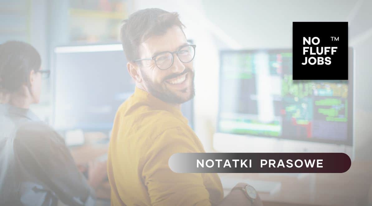 Zdjęcie przedstawia młodego mężczyznę pracującego przed monitorem, który jest odwrócony w stronę czytelnika i uśmiechnięty. Po prawej stronie znajduje się logo No Fluff Jobs, u dołu tytuł działu: Notatki Prasowe.