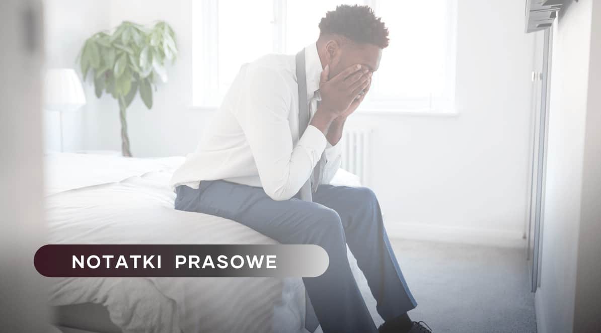 Ilustracja do artykułu: Ile wynoszą straty z powodu depresji pracowników?..., przedstawia mężczyznę siedzącego na łóżku z twarzą schowaną w dłoniach. Po lewej stronie znajduje się tytuł działu: Notatki Prasowe.